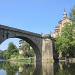 View of the Medieval bridge and monastery from a row boat in the river, Amarante